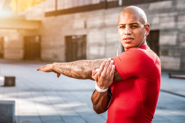 Entrainement sportif. Homme gentil sérieux faisant différents exercices physiques tout en ayant une séance d'entraînement