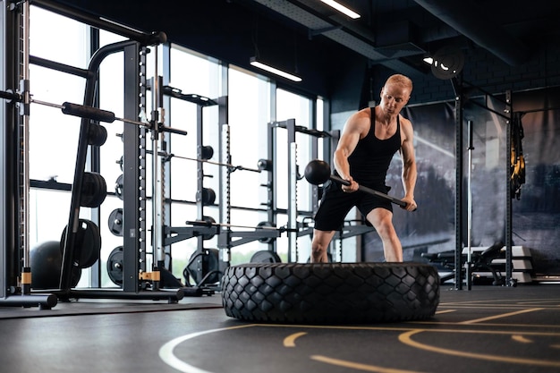 Entraînement sportif pour l'endurance homme fort frappant le marteau Concept d'entraînement crossfit