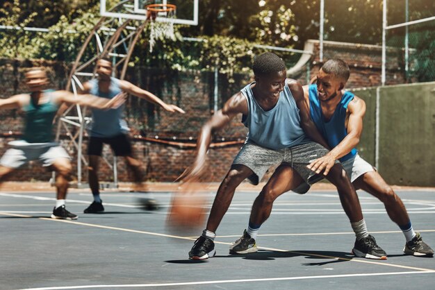 Entraîner le basket-ball et les amis sur un terrain de basket-ball en s'amusant dans un jeu de compétition et en riant idiot et joyeux Sports d'énergie et joueurs de basket-ball en compétition pour le ballon dans l'entraînement de liaison