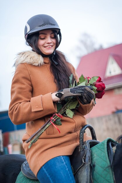 Entraîner des femmes avec des fleurs et des chevaux en marchant sur l'hippodromexA