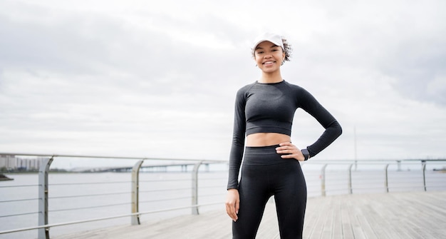 L'entraîneur de course porte un survêtement en baskets Une coureuse sportive utilise une montre de fitness