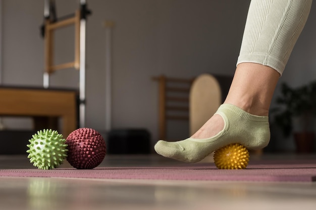 Photo entraîneur faisant des exercices d'étirement des jambes avec des élastiques de fitness orange entraîneur de fitness faisant des exercices