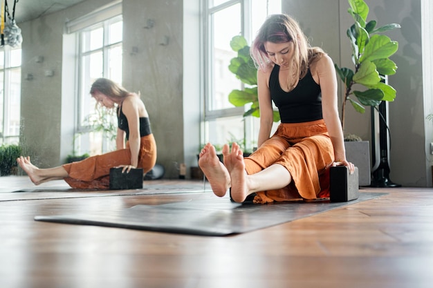 Un entraîneur féminin fait l'exercice de pose de yoga asana