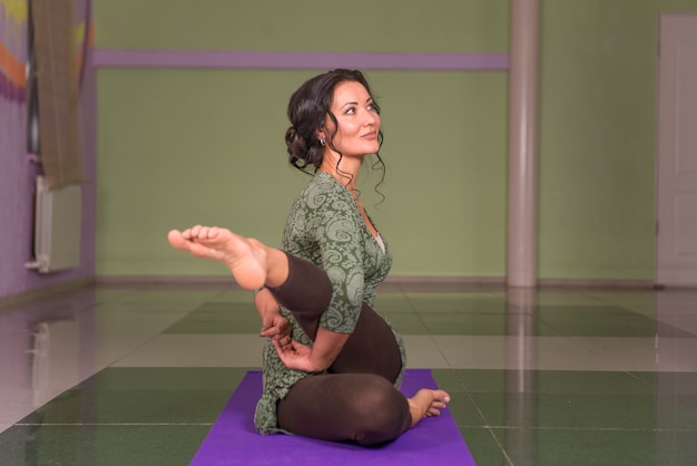 Entraîneur féminin montrant des asanas de yoga dans la salle de sport