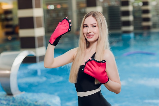 entraîneur femme avec des gants dans l'eau de la piscine pour enfants et adultes