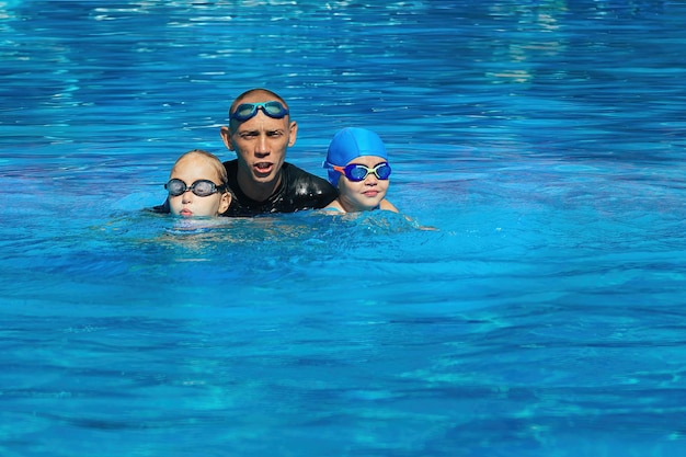 L'entraîneur de natation organise une leçon individuelle avec la fille dans la piscine extérieure