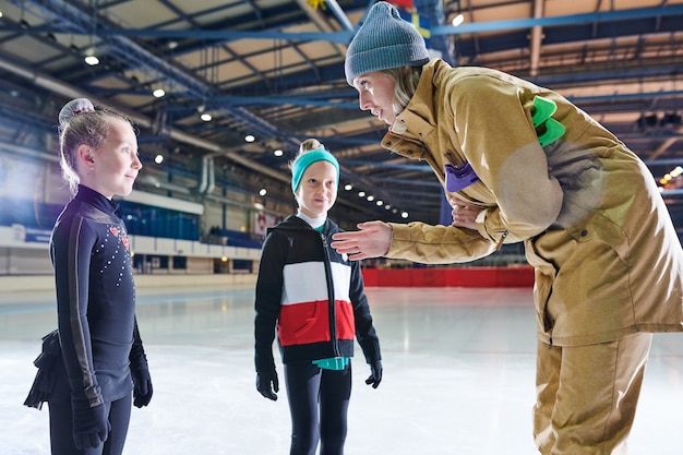 Entraîneur de patinage sur glace motivant les enfants