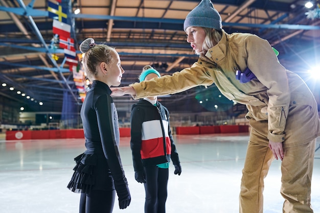 Entraîneur de patinage sur glace motivant les enfants