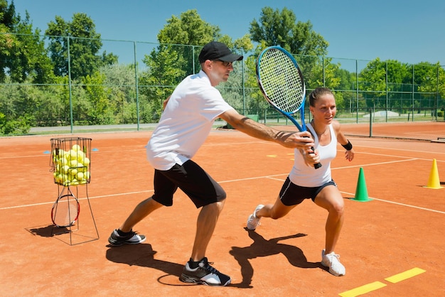 Entraîneur de tennis travaillant avec une étudiante