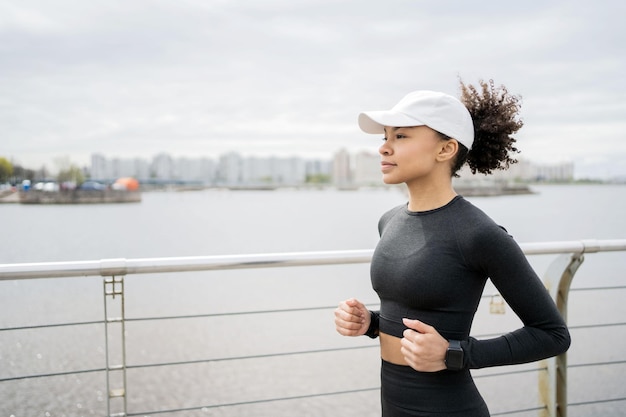 Une entraîneure de coureurs est activement engagée dans des courses sportives dans la ville s'entraîne à l'extérieur dans des vêtements de sport