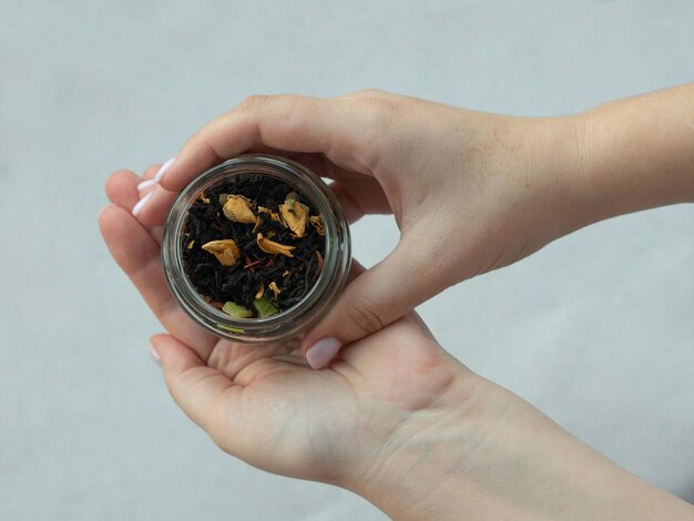 Entre les mains d'une femme un pot avec une tisane aromatique