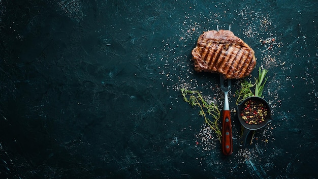 Entrecôte de bœuf grillée sur la fourchette À la table vieillie Vue de dessus Espace libre pour votre texte