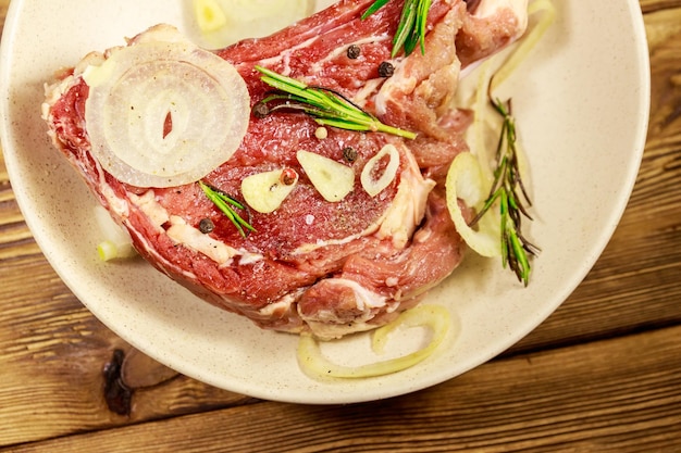 Entrecôte de boeuf marinée sur os avec épices oignon et romarin sur table en bois