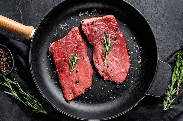 Entrecôte crue dans une poêle. Viande de boeuf. Vue de dessus