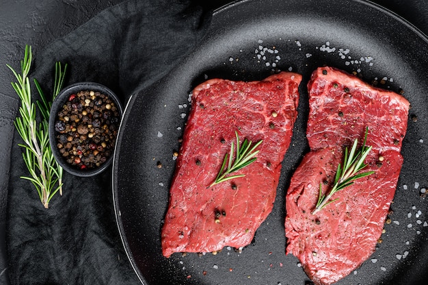 Entrecôte crue dans une poêle. Viande de boeuf. Vue de dessus