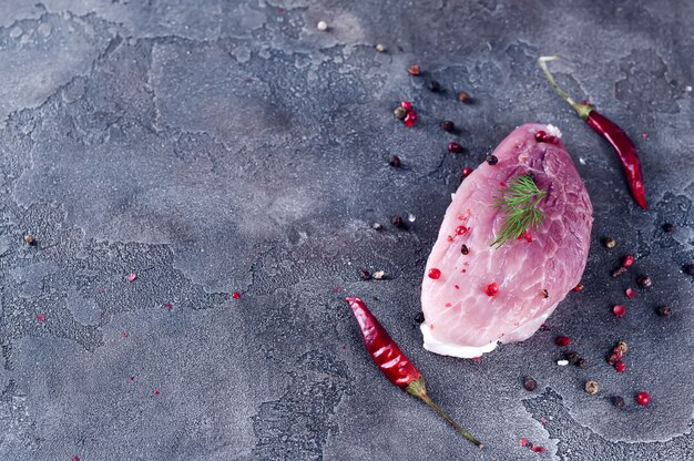 Entrecôte de steak de viande fraîche crue et assaisonnements dans la plaque de fer avec huile, piment, aneth et épices