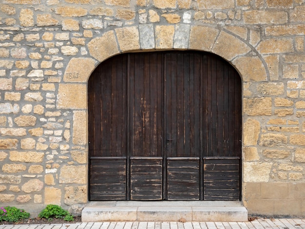 Entrée de l'ancien bâtiment de double porte en bois fermée avec arche sur l'ancienne rue