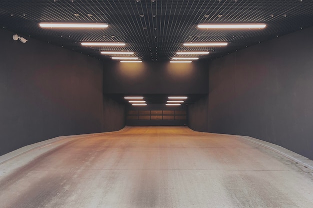 Photo entrée éclairée surveillée du garage souterrain avec une porte verrouillée