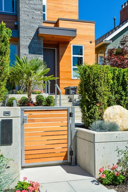 Entrée d'une nouvelle maison familiale de luxe avec une cour avant aménagée