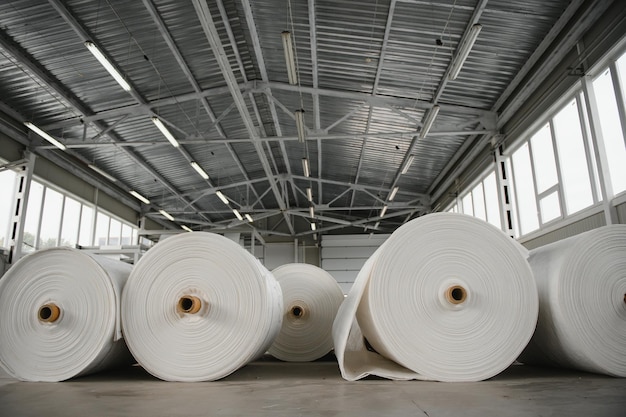 Entrepôt de matières premières. De nombreuses grandes bobines de tuyau en propylène fini en fil tissé pour la fabrication de sacs industriels. Rouleaux de polypropylène pour l'emballage.