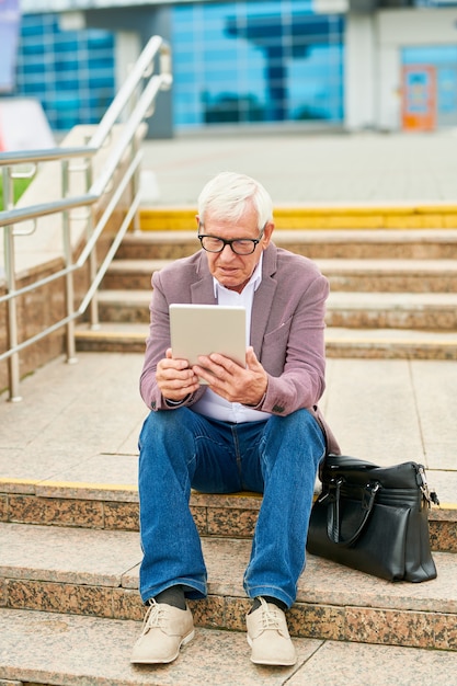 Entrepreneur âgé avec tablette sur les marches