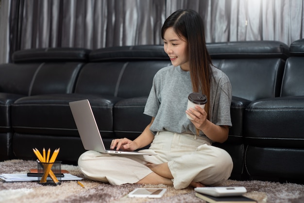 Entrepreneur asiatique ou pigiste travaillant à la maison avec un ordinateur portable