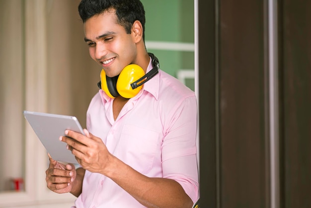 Entrepreneur charpentier indien intelligent avec lunettes et casque vérifier corniche de plafond blanc pour le concept de maison de décoration intérieure