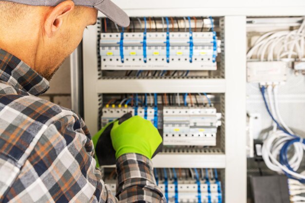 Photo entrepreneur électricien caucasien installant des technologies d'alimentation électrique résidentielle