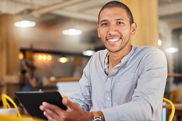 Entrepreneur indépendant ou designer travaillant en ligne tenant une tablette numérique assis dans un café ou un restaurant Homme d'affaires prospère avec un horaire flexible travaillant à distance sur Internet dans un café