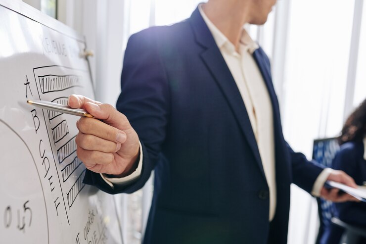 Photo entrepreneur pointant sur le diagramme sur le tableau blanc