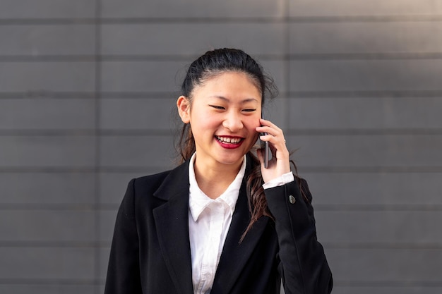 Entrepreneur souriant femme asiatique parlant par téléphone