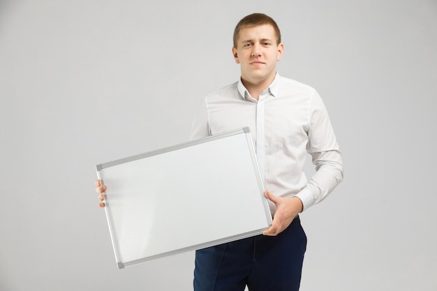 Entrepreneur avec un tableau magnétique dans ses mains blanc