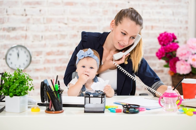 Photo entreprise familiale - télétravail femme d'affaires et mère avec enfant passe un appel téléphonique