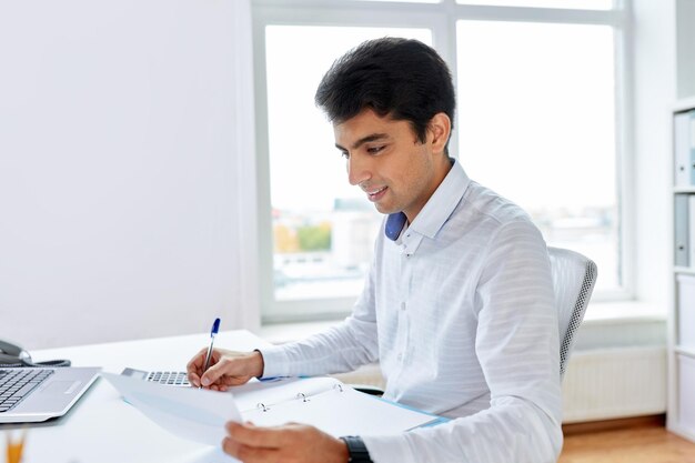 entreprise et les gens concept homme d'affaires avec des papiers et un ordinateur portable travaillant au bureau