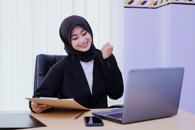 Entreprise positive jeune femme gaie au bureau obtenir une nouvelle idée tenant un rapport financier travaillant