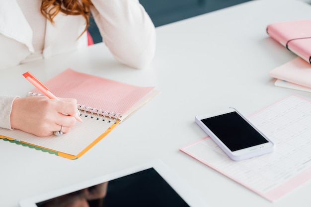 entreprise de réseau social. marketing en ligne. smm femme sur le lieu de travail prenant des notes dans le calendrier.