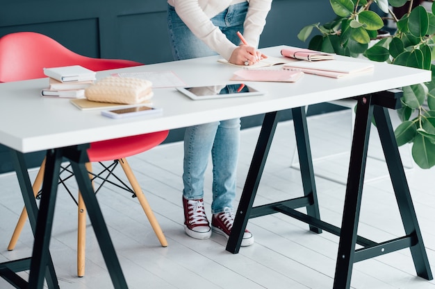 entreprise de réseau social. marketing en ligne. smm femme sur le lieu de travail prenant des notes dans le calendrier.