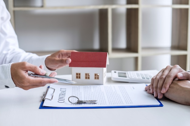 Entreprise signant un contrat Achat - vente, agent d’assurance analysant les investissements dans le logement
