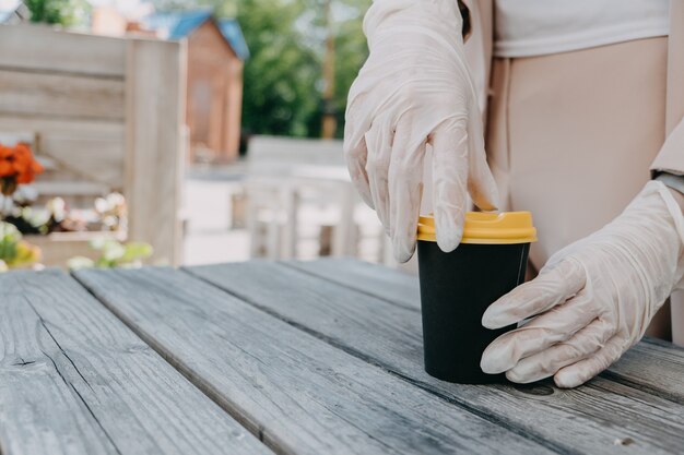 Entreprises d'aliments et de boissons pendant le café pandémique du coronavirus pour emporter une tasse à emporter dans les mains des femmes dans