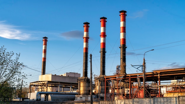 Entreprises industrielles avec des tuyaux contre le ciel bleu.