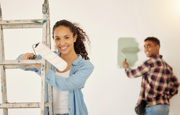 Photo entretien de bricolage et couple de peinture pour la construction de projets de rénovation domiciliaire pour la décoration intérieure dans l'appartement et sourire pour un travail de réparation créatif heureux homme et femme peintre travaillant dans la chambre ensemble