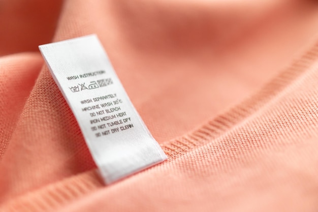 Entretien du linge blanc instructions de lavage étiquette de vêtements sur chemise en coton rose