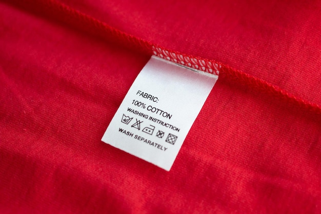 Entretien du linge blanc instructions de lavage étiquette de vêtements sur une chemise en coton rouge