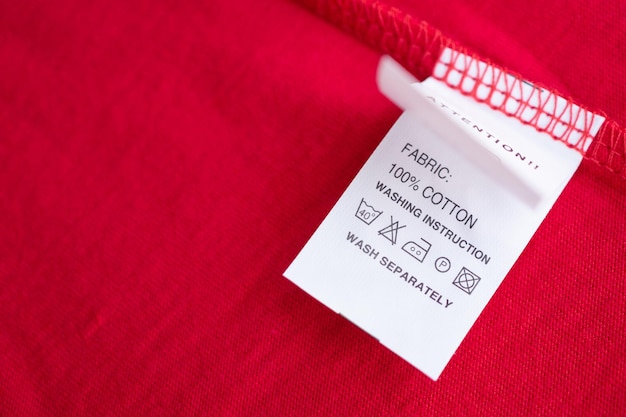 Entretien du linge blanc instructions de lavage étiquette de vêtements sur une chemise en coton rouge