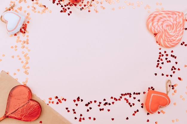 Enveloppe artisanale à côté de coeurs caramel et d'un panier en osier aux couleurs rose pastel. Contexte de la Saint-Valentin.