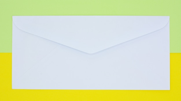 Enveloppe blanche courrier sur fond jaune et vert