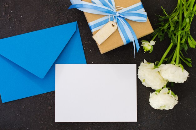 Enveloppe bleue avec papier blanc vierge et cadeau