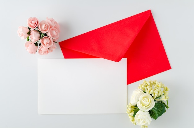 Enveloppe avec carte avec roses sur fond blanc