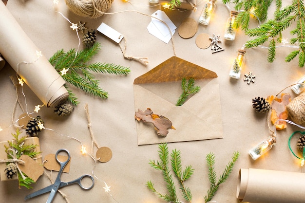 Enveloppe avec félicitations pour Noël et nouvel an en matériaux écologiques : papier kraft, branches de sapin vivantes, cônes, ficelle. Maquette d'étiquettes, décor naturel, fait à la main. Lettre pour le Père Noël. Catégoriquement