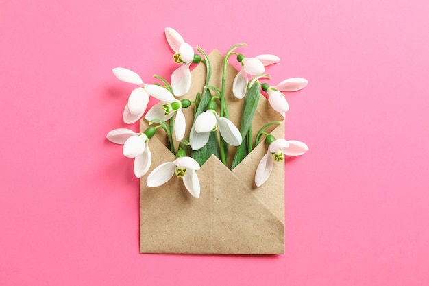 Enveloppe avec des fleurs de perce-neige sur fond de couleur, espace pour le texte